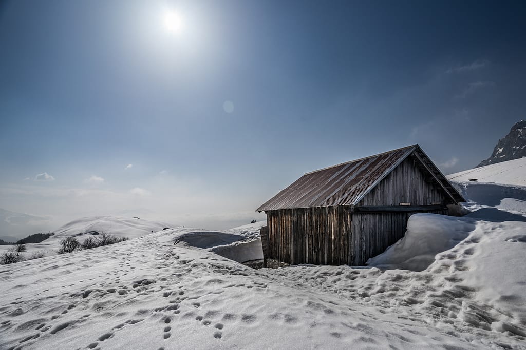 cabane dans la montagne en hiver sous le soleil