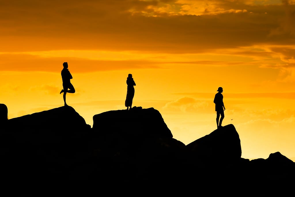 Silhouettes de personnes à contre-jour pendant un coucher de soleil - Photographie par Theo Cohen